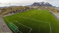 Usut punya usut, lapangan di tengah pulau kecil ini dinobatkan sebagai lapangan bola terindah di dunia. Lapangan ini bernama Stadion Henningsvaer, berada di tengah-tengah pulau kecil dengan pemandangan sekitarnya laut biru (Henningsvaer IL/Facebook)