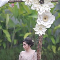 Paper flower tidak harus selalu ditempel sebagai backdrop. Anda juga bisa menaruhnya sebagai pemanis di tempat lain, seperti batang pohon ala Angela dan Ajat ini. Dekorasi paper flower berikut cocok jadi inspirasi lamaran atau pernikahan outdoor. (Foto: Bride Dept)