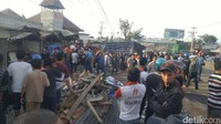 Tampak pula kontainer berwarna biru terguling di pinggir jalan. Di dekatnya ada banyak reruntuhan warung. Foto: Angling Adhitya Purbaya