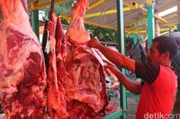 Menggantung daging saat memotong.