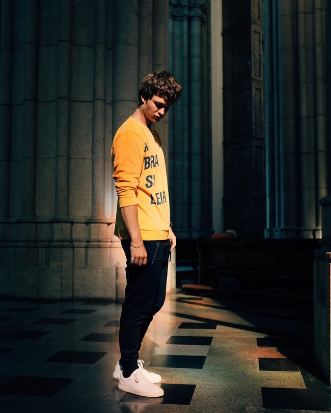 Ansel Elgort tampil casual dengan sneakers, celana joger dan sweater berwarna kuning saat travelling ke Brazil. Foto: Dok. Instagram
