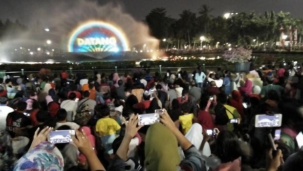Sebagian pengunjung duduk di area yang disediakan sedangkan sebagian lain menonton sambil berdiri.