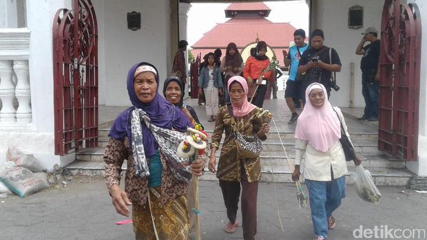 Warga Yogya membawa pulang hasil rebutan Gunungan Grebeg Besar, Keraton Yogyakarta.