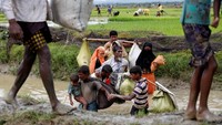 Seorang ayah menggandeng anak laki-lakinya untuk menyeberangi kanal. (Foto: Mohammad Ponir Hossain/Reuters)