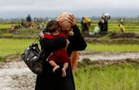 Pengungsi Rohingnya membawa anak balitanya menyeberangi perbatasan Bangladesh.