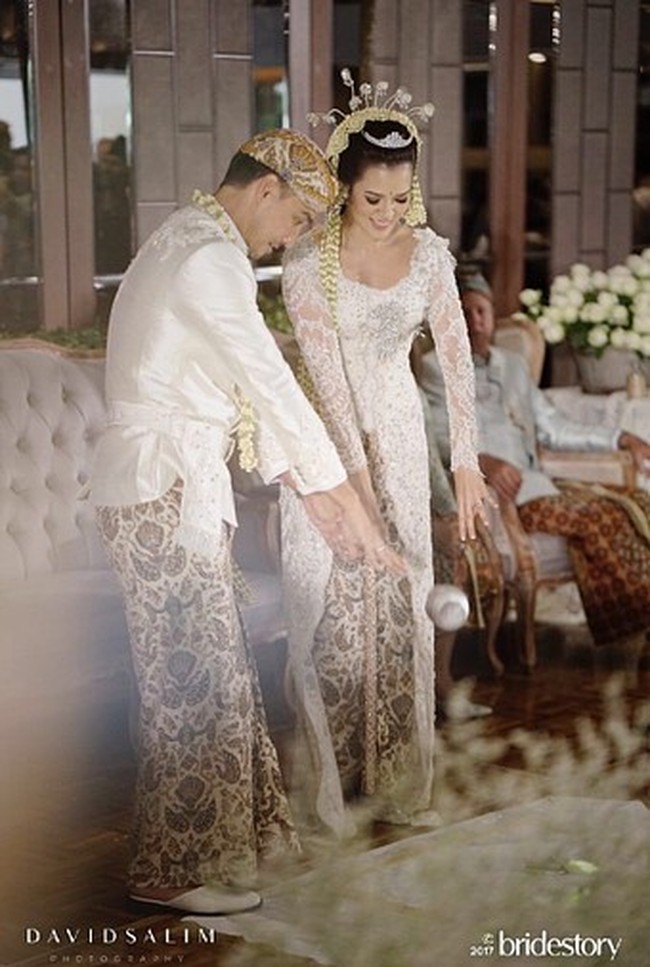 Tampak memakai lace Prancis dengan warna gading, tampilan kebaya begitu mewah dengan aplikasi payet, manik dan aplikasi bunga 3D sampai bagian tail yang panjang menyapu lantai. Foto: Dok. Instagram/Bridestory