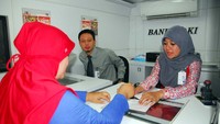 Tampak Petugas Bank DKI sedang melayani nasabah dan wajib pajak di dalam mobile branch di Rusun Jatinegara Barat di Jakarta.  Foto: dok. Bank DKI
