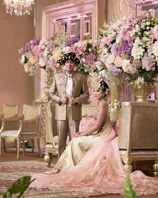 Kebaya pengantin adat Batak ala Zivanna Letisha tampil lebih manis dengan pilihan kebaya berwarna dusty pink dan emas. Tampilan kebaya pun tampak modern berkat aplikasi bahan transparan pada kebaya rancangan Intan Avantie. Foto: Dok. Instagram