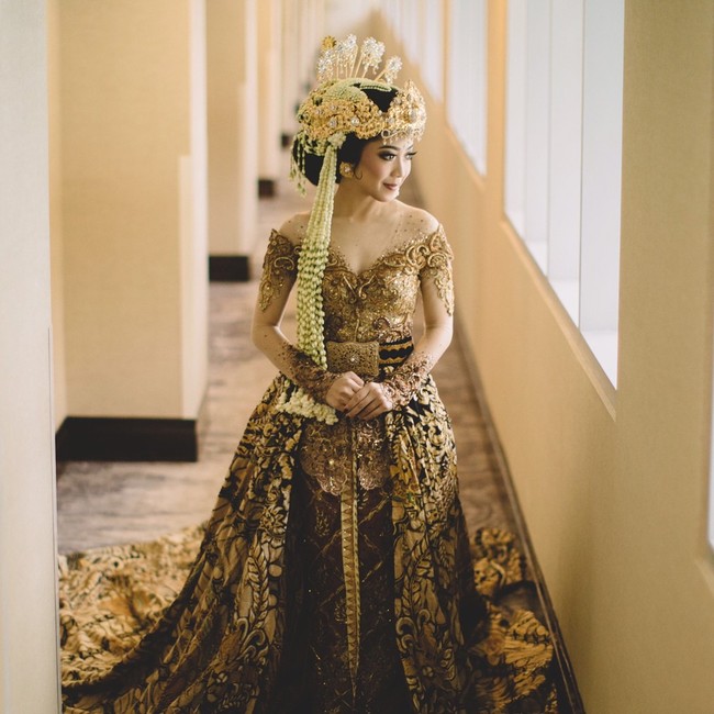 Karina Salim tampil cantik dengan kebaya emas rancangan Anne Avantie yang tampak megah dengan tambahan tail dari kain batik. Penampilan pengantin pun tampak lebih mewah dengan atribut ala pengantin Sunda di hari besarnya. Foto: Dok. Instagram