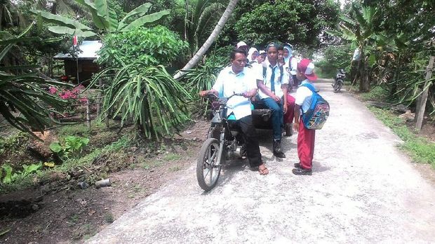 Syafrizal menjemput siswa sekolahnya menggunakan gerobak motor miliknya tiap pagi