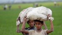 Dengan memikul beban, mereka berjalan melintasi perbatasan Bangladesh-Myanmar. REUTERS/Mohammad Ponir Hossain.