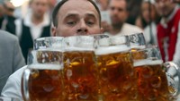 Seorang pria bernama Oliver Struempfel asal Jerman, saat membawa 27 gelas bir berukuran 1 liter. REUTERS/Michael Dalder.