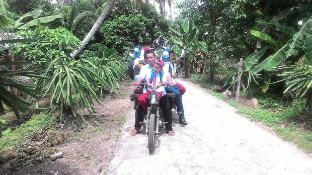 Syafrizal menggunakan gerobak motor untuk menjemput siswanya ke sekolah