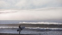 Berselancar di sekitar Reykjanes, Islandia, menghadirkan berbagai tantangan. Paling tidak suhu beku akan membuat traveler berpakaian selam dan memakai pelindung kaki agar tidak terkena hipotermia (Dok. CNN Travel)