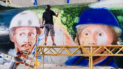 Begini Proses Mural Warkop DKI Reborn di Pesawat