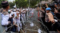 Polisi berusaha menenangkan massa.