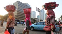 Ketiga perempuan melintas di Jalan Thamrin untuk menjajakan kopi.