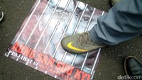 Peserta aksi menginjak poster Aung San Suu Kyi.