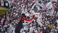 Bendera merah putih dikibarkan saat massa bergerak ke lokasi aksi. Ada juga yang membawa bendera Palestina (Foto: ANTARA FOTO/Akbar Nugroho Gumay)