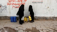 Untuk memperoleh air bersih saja, dua wanita ini harus mengantre mengisi jeriken yang kosong. (Foto: Reuters)