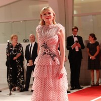 Kristen Dunst tampil feminin dengan gaun pink berhiaskan motif polkadot dan ruffle bertumpuk dari Rodarte. (Foto: Getty Images(