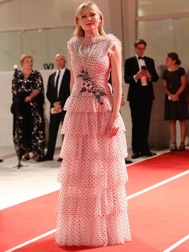 Kristen Dunst tampil feminin dengan gaun pink berhiaskan motif polkadot dan ruffle bertumpuk dari Rodarte. (Foto: Getty Images(