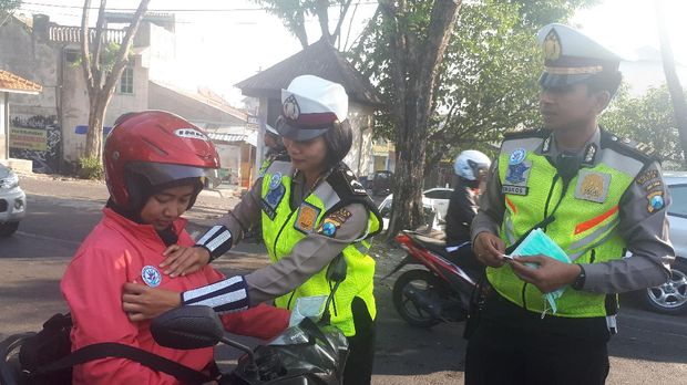Polisi membagikan dan memasang pin pengingat keselamatan
