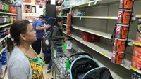 Bahkan di pusat perbelanjaan rak untuk air minum ludes di borong warga (REUTERS/Joe Skipper)