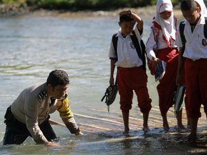 Polisi Ini Bantu Siswa SD Naik Rakit Seberangi Sungai di Gorontalo