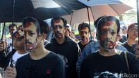 Massa aksi tampak memakai topeng Munir.