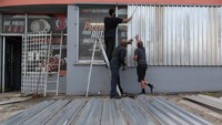Untuk meminimalisir kerusakan, para warga menutup jendela rumah dengan seng (REUTERS/Alvin Baez)