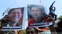 Massa membawa poster bergambar Aung San Suu Kyi.