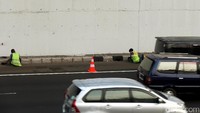 Marka jalan dipasang untuk melindungi para pekerja yang tengah mengecat.