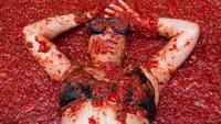 Setelah beberapa jam saling lempar tomat, yang tersisa hanyalah lautan jus tomat. Traveler ini pun berendam di atas kolam tomat yang dihasilkan selama La Tomatina berlangsung (Heino Kalis/Reuters)