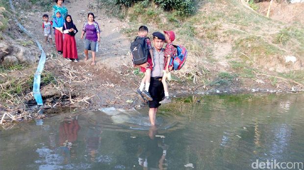 Polisi gendong siswa SD terobos sungai