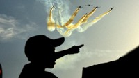 Seorang warga melihat atraksi manuver yang dilakukan tim Jupiter TNI AU.