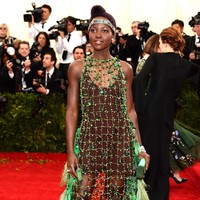 Gaun hijau pendek dengan luaran jaring rancangan Prada menemani penampilan Lupita Nyongo di Met Gala 2014. Foto: Getty Images