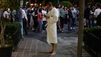 Tamu hotel yang mengenakan bathrobe terlihat berdiri sambil memegangi ponselnya (Foto: AFP PHOTO/LUIS PEREZ)