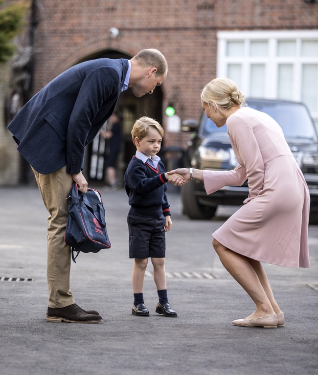 Kehadiran George lalu disambut oleh Head of Lower School di sekolahnya, yaitu Helen Haslem yang memakai gaun pink.  Foto: Dok. Getty Images/Kensington Palace