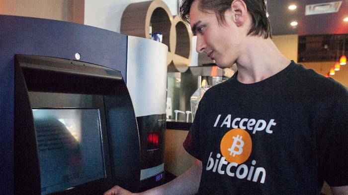 VANCOUVER, BC - OCTOBER 29: Gabriel Scheare uses the worlds first bitcoin ATM on October 29, 2013 at Waves Coffee House in Vancouver, British Columbia. Scheare said he just felt like being part of history. The ATM, named Robocoin, allows users to buy or sell the digital currency known as bitcoins. Once only used for black market sales on the internet, bitcoins are starting to be accepted at a growing number of businesses. (Photo by David Ryder/Getty Images)