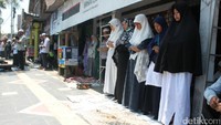 Jamaah melaksanakan salat gaib di jalan raya. Bahkan beberapa di antaranya salat di emperan toko di depan masjid. (Pertiwi/detikcom)