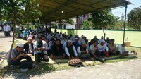 Ada pula yang duduk-duduk di depan masjid sambil makan siang menunggu waktu salat (Pertiwi/detikcom)