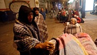 Warga Meksiko memilih menahan dinginnya malam dan berada di luar rumah (Foto: REUTERS/Edgard Garrido)