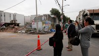 Sejumlah warga melihat reruntuhan bangunan akibat gempa. Terlihat beberapa di antara mereka juga mengabadikan sisa puing-puing rumah. (Foto: Carlos Jasso/Reuters)
