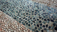 Ya, pada bagian lantai tengah jembatan terdapat hiasan yang terbuat dari lempengan batu bacan. Batu-batu ini disusun sedemikian rupa sehingga menjadi lantai mozaik yang unik (Wahyu/detikTravel)