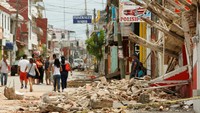 Warga berjalan melewati sebuah bangunan yang hancur di Juchitan. (REUTERS/Jorge Luis Plata)