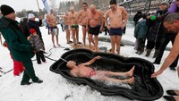Winter swimming juga dijadikan ajang kumpul-kumpul bagi para orang tua. Mereka akan menyiram tubuh mereka terlebih dahulu di bathtube yang sudah disediakan (Ilya Naymushin/Reuters)