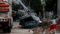 Sebuah tembok yang rusak dan kendaraan yang hancur di Mexico City. (REUTERS/Carlos Jasso)