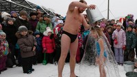 Anak-anak Rusia pun mulai di perkenalkan dengan olahraga ekstrem ini sejak kecil. Sebagai perkenalan, anak-anak akan di siram dengan seember air sungai yang sedingin es. Mirip ice bucket challenge (Ilya Naymushin/Reuters)