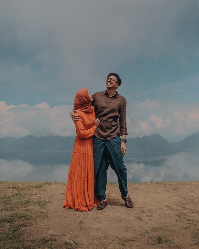 Kebahagiaan Laudya Cynthia Bella dan Engku Emran terlihat di foto kali ini. Engku Emran merangkul mesra Bella saat berdiri di atas bukit dengan pemandangan langit berawan saat foto prewedding outdoor.  Foto: Dok. Instagram @alvasus